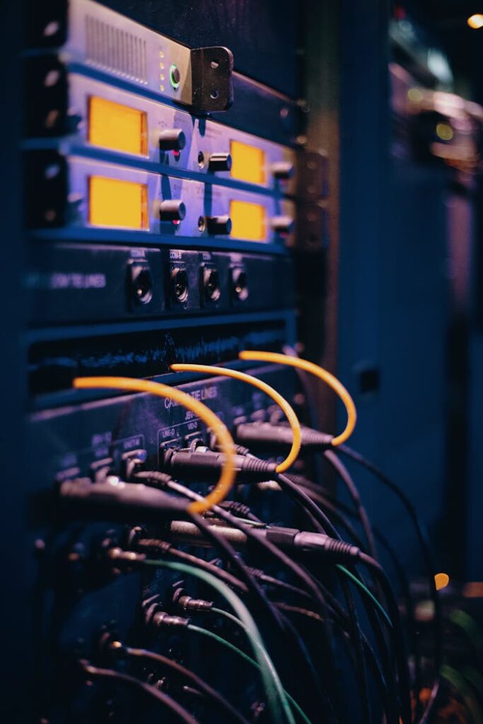 pexels-photo-1054397-4 Close-up of network cables and ports in a server rack, showcasing connectivity.